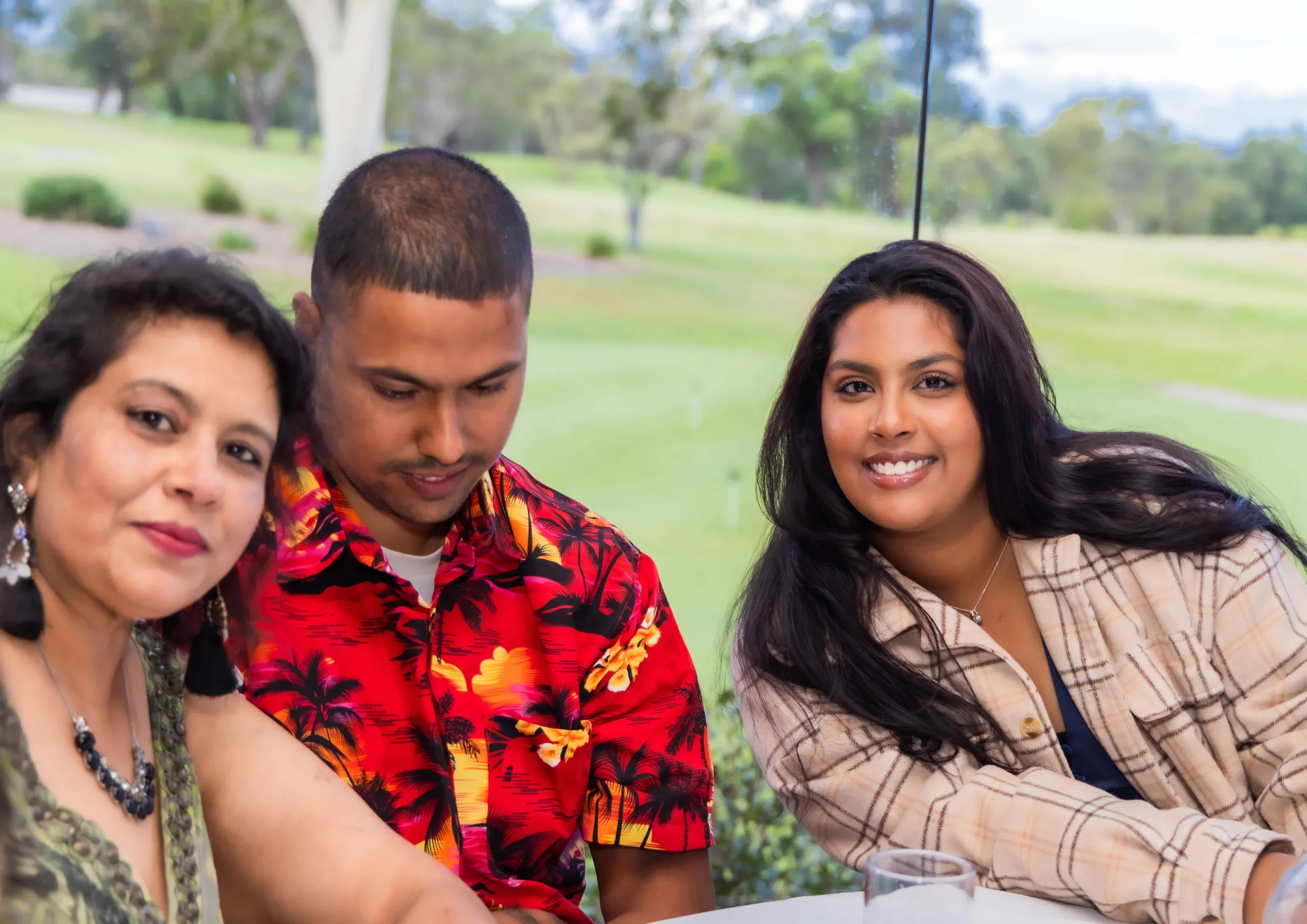 Three diverse individuals sitting at an outdoor event