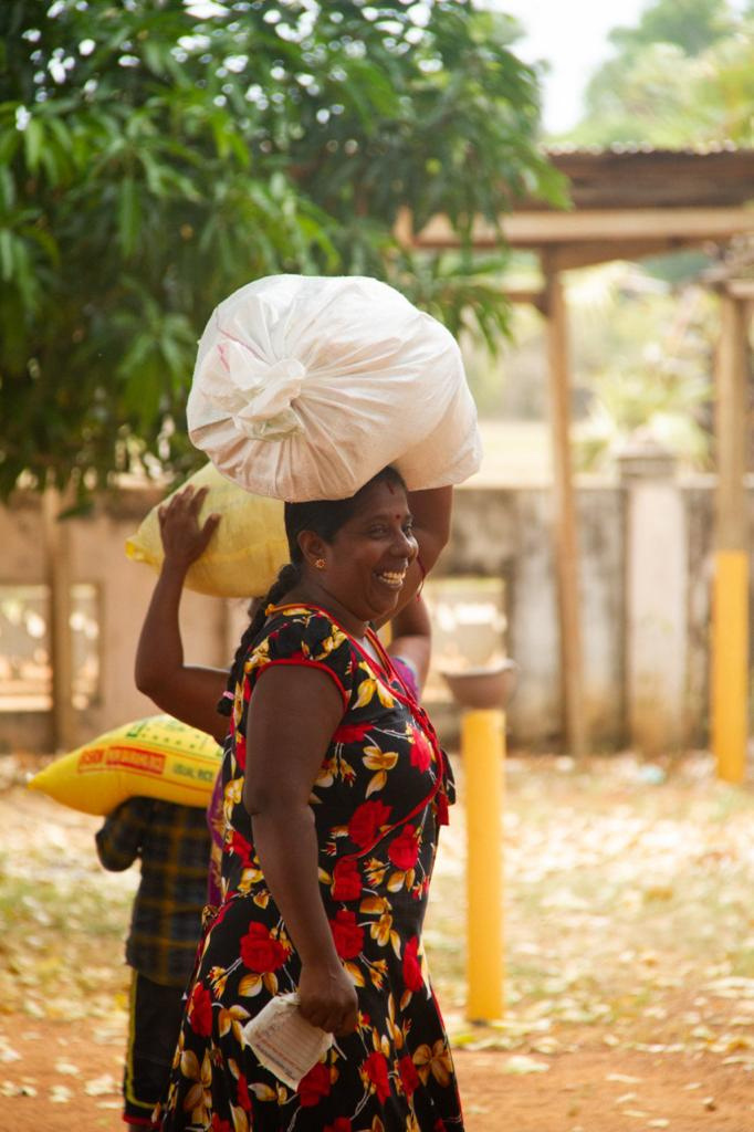 A woman in vibrant attire receiving goods